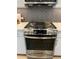 Close up of a stainless steel gas range with black backsplash and light countertops at 120 Mosaic Blvd # 307, Pittsboro, NC 27312