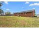 Expansive backyard showcasing a well-maintained lawn and the exterior of a charming brick home at 2169 Northcrest Dr, Elon, NC 27244