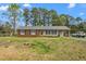 Charming single-story home with brick facade, welcoming front porch and ample yard space at 2169 Northcrest Dr, Elon, NC 27244