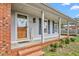 Inviting front porch with brick steps, charming decor, and gray siding at 2169 Northcrest Dr, Elon, NC 27244