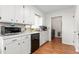Bright kitchen featuring white cabinets, black appliances, and vinyl wood floors at 2169 Northcrest Dr, Elon, NC 27244