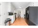 Galley kitchen with white cabinets, black appliances, and vinyl wood floors at 2169 Northcrest Dr, Elon, NC 27244