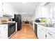 Bright kitchen with white cabinets, stainless steel sink, and black appliances at 2169 Northcrest Dr, Elon, NC 27244