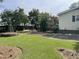 Well-manicured front yard with lush lawn, mature trees, and a charming windmill feature adding curb appeal at 229 Davis Mill Rd, Selma, NC 27576
