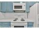 Well-lit kitchen features white appliances and blue cabinetry at 229 Davis Mill Rd, Selma, NC 27576