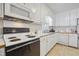 White kitchen with appliances, ample cabinetry and tile floor at 512 Drexel Rd, Rocky Mount, NC 27803