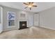 Bright living room with a fireplace, window view, ceiling fan, and neutral tile flooring at 9009 Grassington Way, Raleigh, NC 27615