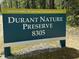 Durant Nature Preserve sign indicating the location, with lush greenery in the background at 9009 Grassington Way, Raleigh, NC 27615