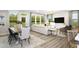 Inviting open-concept living space with a dining area, comfortable seating, and large windows showcasing green views at 1011 Shovelhead Dr # 6, Durham, NC 27703