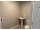 Bathroom featuring a pedestal sink, vinyl floor, and toilet; great for guests or small spaces at 1017 Gaston Ave, Durham, NC 27707