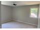 A well-lit bedroom with neutral carpet and paint, plus a ceiling fan and single window at 1017 Gaston Ave, Durham, NC 27707