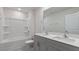 Bright bathroom with gray vanity, double sinks, a large mirror, and a shower-tub combo at 120 Tobacco Woods Dr, Youngsville, NC 27596