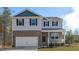Charming two-story home with a brick facade, attached garage, and inviting front porch at 120 Tobacco Woods Dr, Youngsville, NC 27596