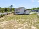 Expansive backyard with a white fence surrounding a two-story white home on a sunny day at 150 Whimbrel Ct, Lillington, NC 27546
