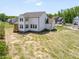 Rear view of the home featuring a screened porch, spacious yard, and modern design at 150 Whimbrel Ct, Lillington, NC 27546