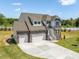 A beautifully landscaped two-story home with a stone facade and attached two-car garage at 150 Whimbrel Ct, Lillington, NC 27546