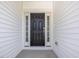 Elegant dark-stained front door framed by sidelights and white trim at 150 Whimbrel Ct, Lillington, NC 27546