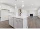Modern kitchen features white cabinets, hardwood floors, and an island with barstool seating at 150 Whimbrel Ct, Lillington, NC 27546