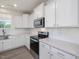 Modern kitchen featuring stainless steel appliances, white cabinets, quartz countertops, and tile backsplash at 150 Whimbrel Ct, Lillington, NC 27546