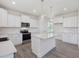 Bright kitchen features white cabinets, stainless steel appliances, and a center island with pendant lighting at 150 Whimbrel Ct, Lillington, NC 27546