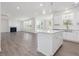Spacious kitchen open to the living room, featuring a center island, white cabinets, and stainless appliances at 150 Whimbrel Ct, Lillington, NC 27546