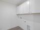 Clean, white laundry room with ample cabinet space and modern gray vinyl flooring at 150 Whimbrel Ct, Lillington, NC 27546