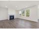 Living room with gray hardwood floors, fireplace and lots of natural light at 150 Whimbrel Ct, Lillington, NC 27546