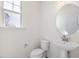Simple powder room featuring a pedestal sink, a toilet, and a window at 150 Whimbrel Ct, Lillington, NC 27546