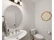 Stylish powder room with a pedestal sink, oval mirror, and decorative wall art at 254 Dungannon, Clayton, NC 27520