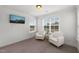 Cozy sitting room with neutral carpet, two white armchairs, natural light, and a mountain view on TV at 254 Dungannon, Clayton, NC 27520