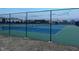 Well-maintained community tennis courts with vibrant blue and green surfaces enclosed by a black chain-link fence at 254 Dungannon, Clayton, NC 27520