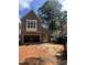 New brick home exterior with an attached garage and unfinished yard under a sunny, cloudy sky at 3302 Hall Pl, Raleigh, NC 27607