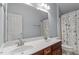 Well-lit bathroom with a double sink vanity, seashell shower curtain, and ample storage at 4324 Brighton Ridge Dr, Apex, NC 27539