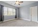 Bright bedroom features neutral walls, carpet, a ceiling fan, and a large window with natural light at 4324 Brighton Ridge Dr, Apex, NC 27539