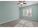 Bright bedroom features neutral walls, carpet, a ceiling fan, and a large window with natural light at 4324 Brighton Ridge Dr, Apex, NC 27539