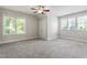 This bedroom is brightly lit, with two large windows, carpeted floors and a ceiling fan at 4324 Brighton Ridge Dr, Apex, NC 27539