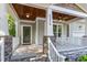 Inviting front porch featuring stone accents, comfortable seating, and a stylish ceiling fan at 4324 Brighton Ridge Dr, Apex, NC 27539