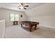 Spacious game room featuring a pool table, ceiling fan, and natural light at 4324 Brighton Ridge Dr, Apex, NC 27539