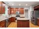 Well-lit kitchen with stainless steel appliances, granite countertops, wooden cabinets, and an island at 4324 Brighton Ridge Dr, Apex, NC 27539