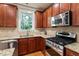 Close up view of a kitchen featuring wooden cabinetry, granite countertops, and stainless steel appliances at 4324 Brighton Ridge Dr, Apex, NC 27539