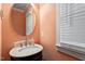 Cozy powder room featuring a unique circular mirror and pedestal sink at 4324 Brighton Ridge Dr, Apex, NC 27539