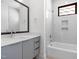 Bathroom with a large mirror, white cabinetry, a tub and shower combination, and a neutral color scheme at 512 Gordon Street # 602, Durham, NC 27701