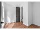 Bright bedroom featuring hardwood floors, white walls and trim, and a large door that leads to a bathroom at 512 Gordon Street # 602, Durham, NC 27701