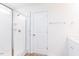 Bright bathroom features a walk-in glass shower, white walls and white door with a towel rack at 59 Davinhall Dr, Fuquay Varina, NC 27526