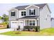 Two-story home featuring a two-car garage, stone accents, and beautifully landscaped front yard at 59 Davinhall Dr, Fuquay Varina, NC 27526