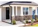 A cozy front porch with a stone base, white columns, and a well-manicured garden at 59 Davinhall Dr, Fuquay Varina, NC 27526