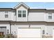 Rear exterior shows two-car garage of a gray townhome with a bright white garage door at 728 Silo Park Dr, Wake Forest, NC 27587