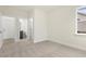 Bright bedroom featuring neutral walls, plush carpet, and a doorway to a bathroom, creating a comfortable and inviting space at 89 Jumper St, Wendell, NC 27591
