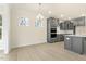 Modern kitchen with gray cabinetry, stainless steel appliances, and bright windows at 89 Jumper St, Wendell, NC 27591