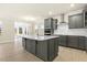 Spacious kitchen with a large island, gray cabinets, and stainless steel appliances at 89 Jumper St, Wendell, NC 27591